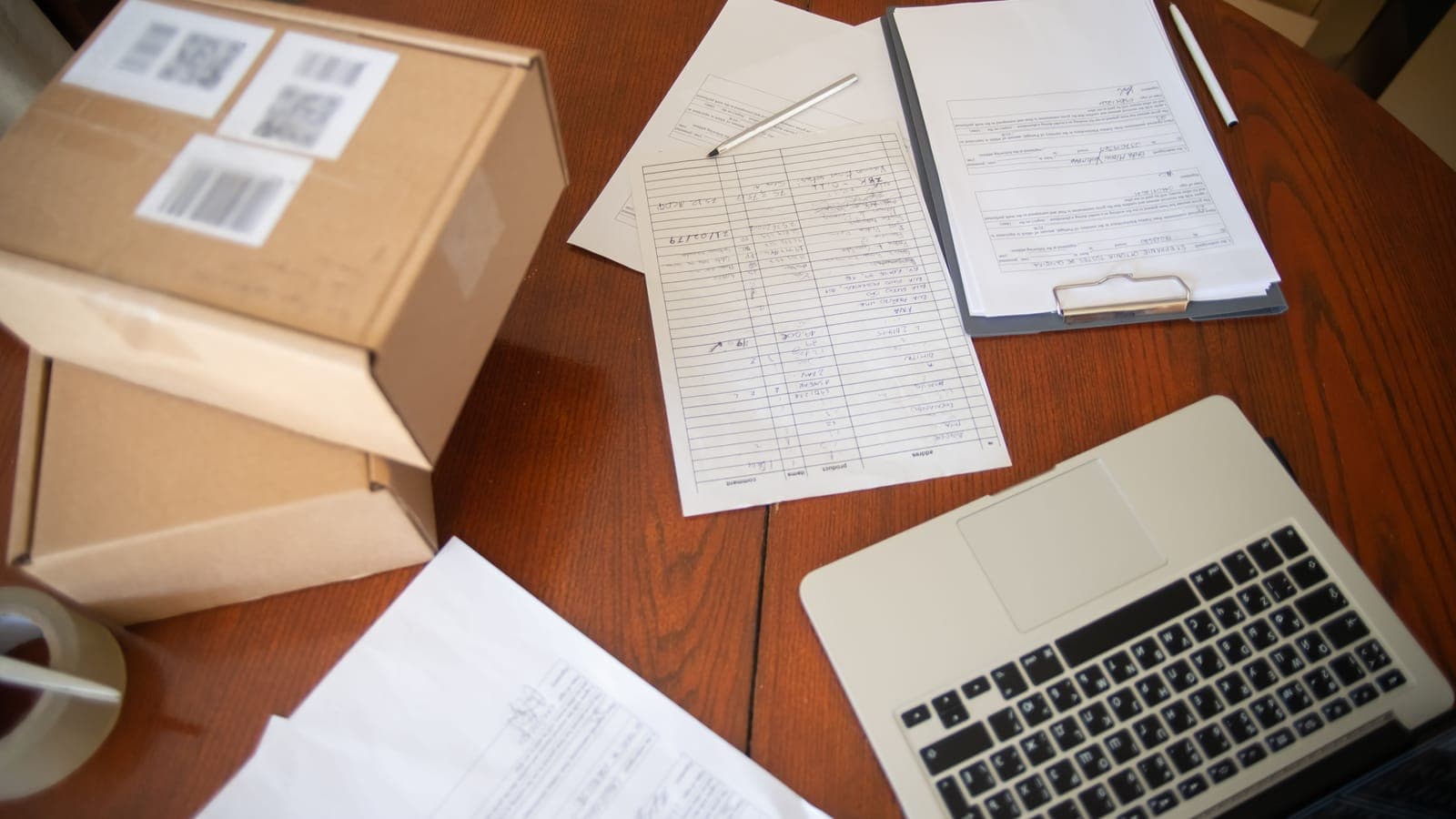 A small-business owner at a desk with a laptop and parcels