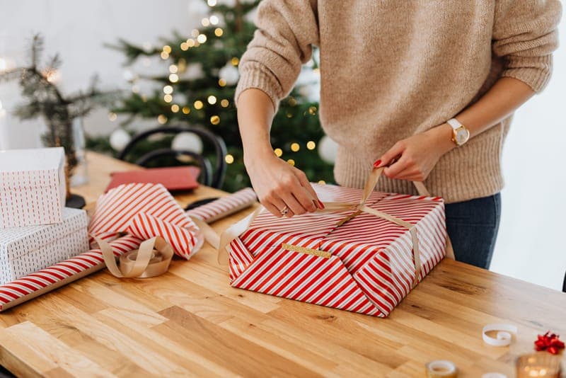 Hands wrapping a Christmas gift