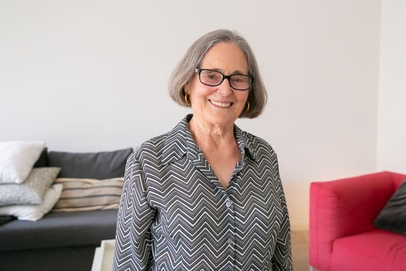A smiling grandmother in glasses, relaxed at home