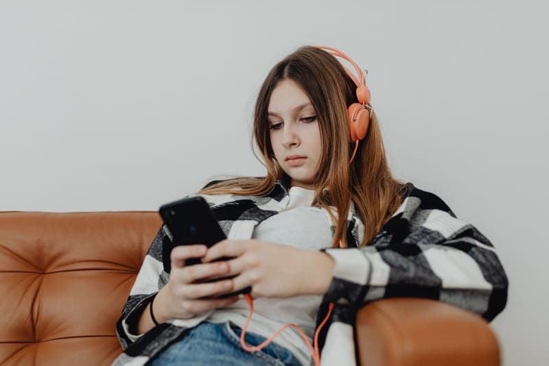 A teenage girl wearing headphones